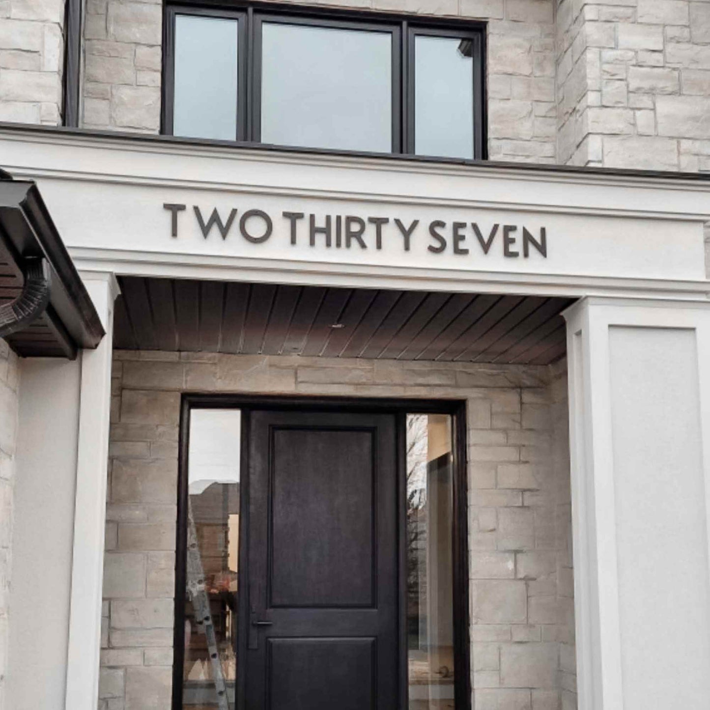 Building entrance with 'Two Thirty Seven' sign on stone facade