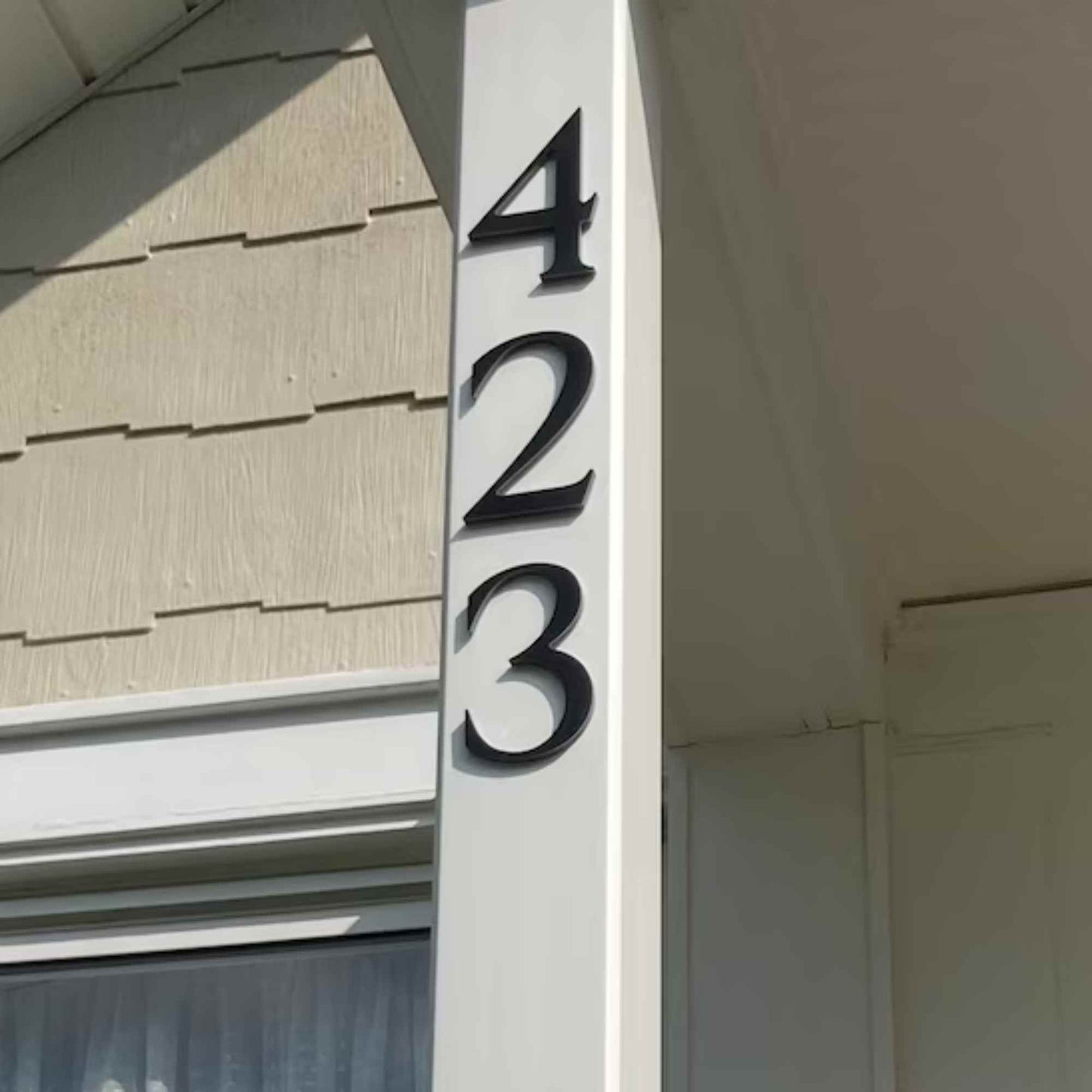 House number '423' on a vertical signboard against a house exterior.