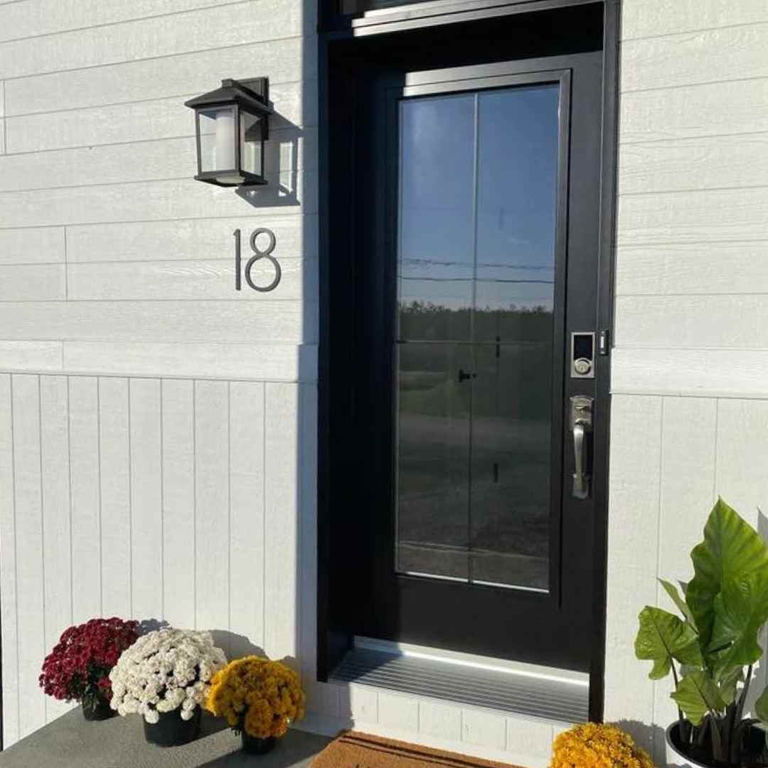 Black front door with white siding and THIN MODERN 8 inch numbers. 