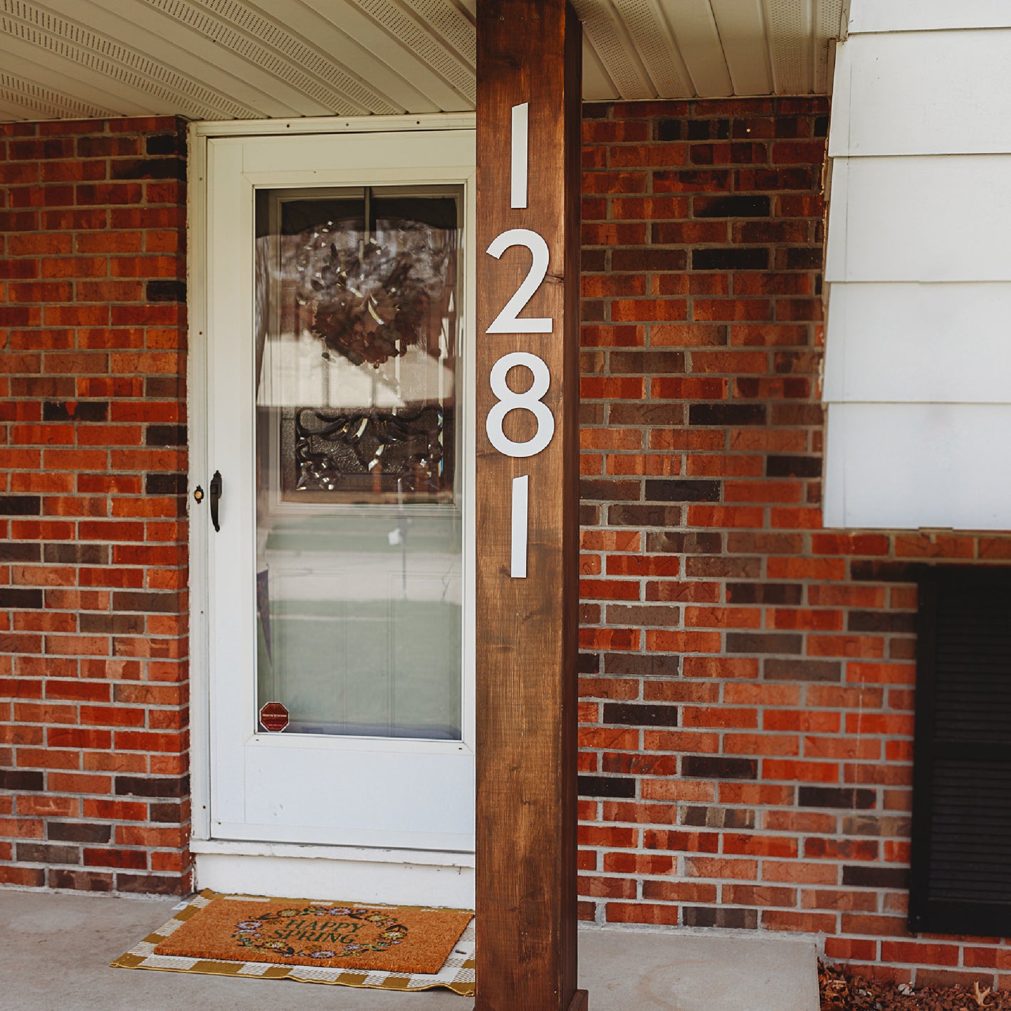 Classic Modern white house numbers on front porch post 
