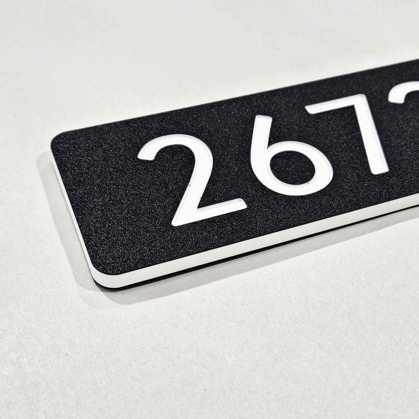 Black rectangular engraved sign plaque with white text