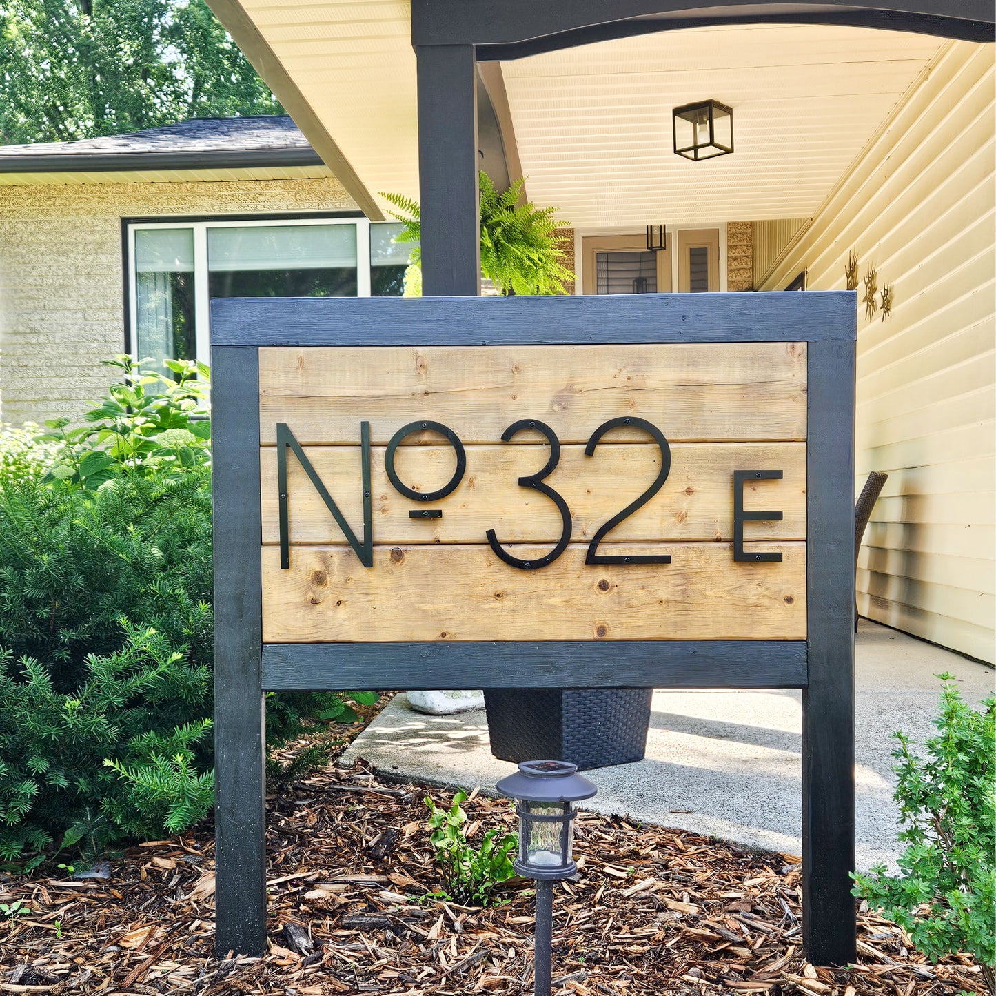 Address sign in the fron yard with 8 inch black house numbers spelling No 32 E