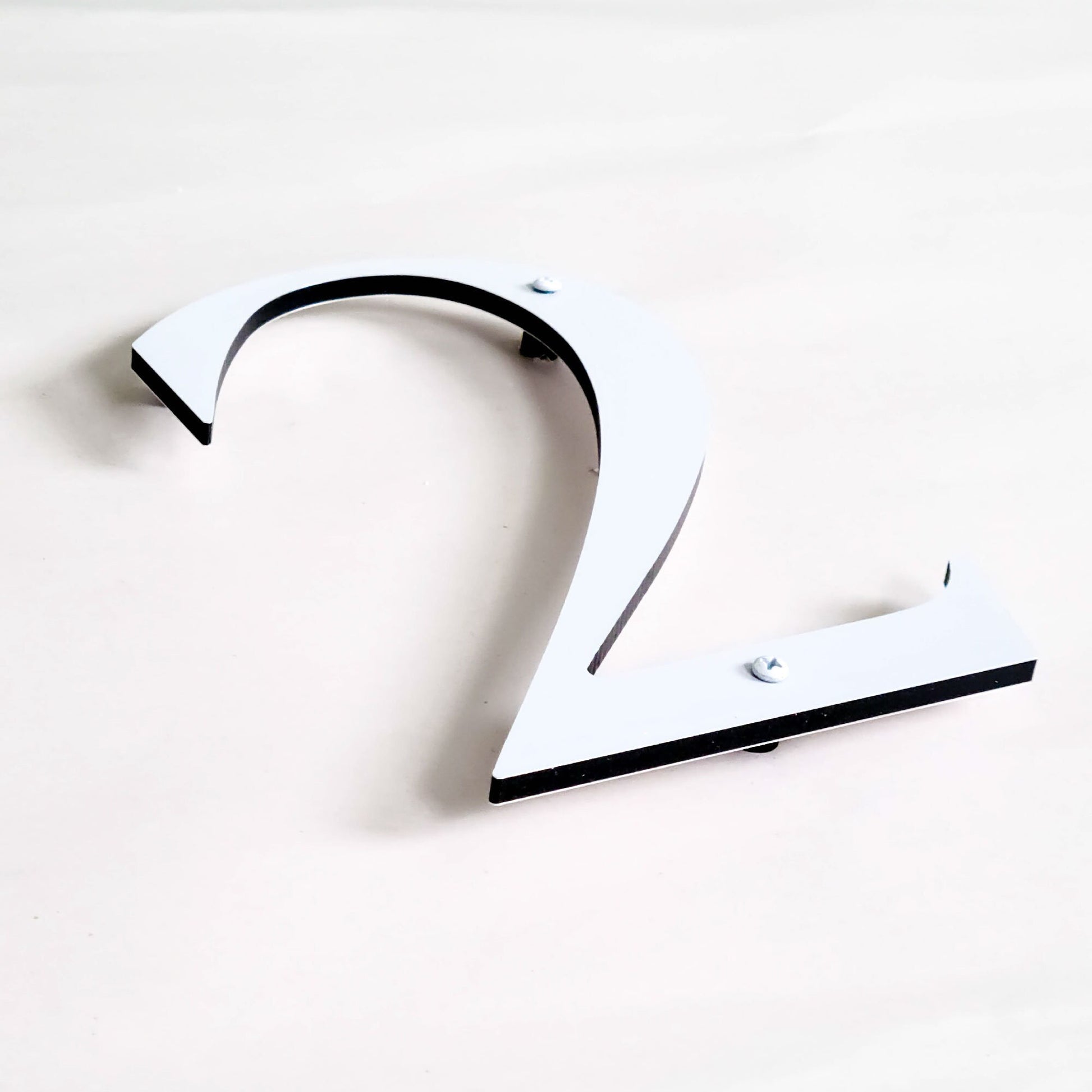 white ROMAN SERIF house numbers with screws and spacers for a floating look